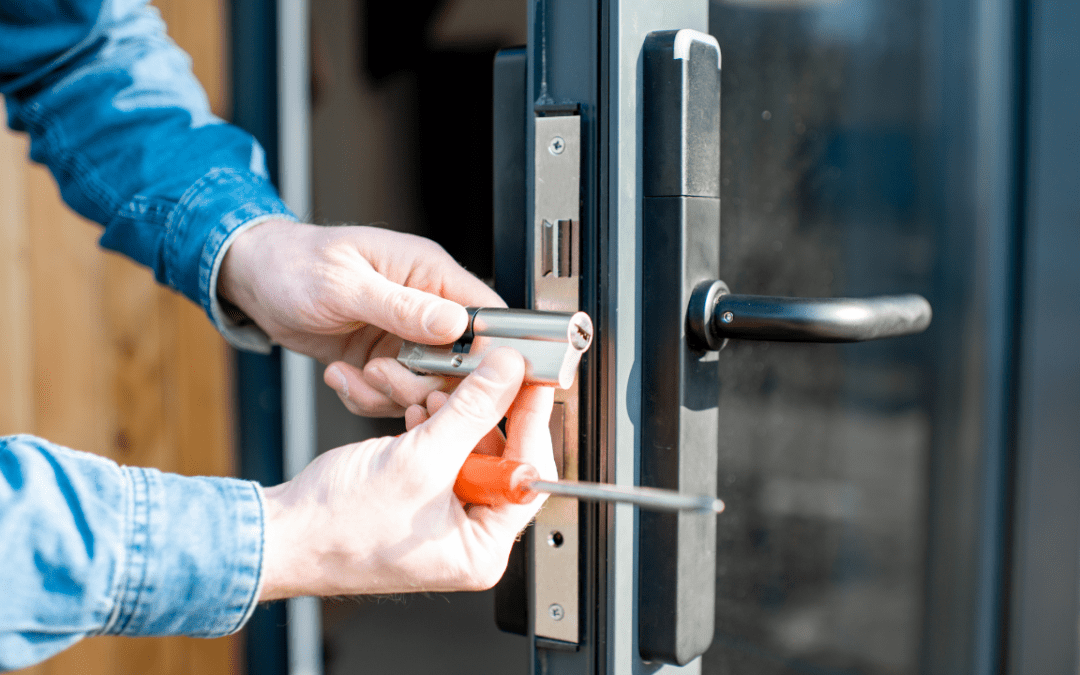 Close-up of hands changing the lock cylinder on a glass door