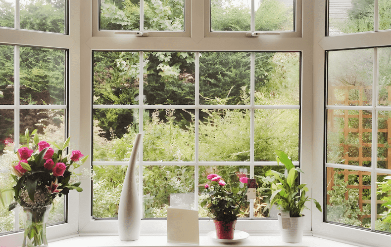 View-of-an-overgrown-garden-through-a-uPVC-bay-window