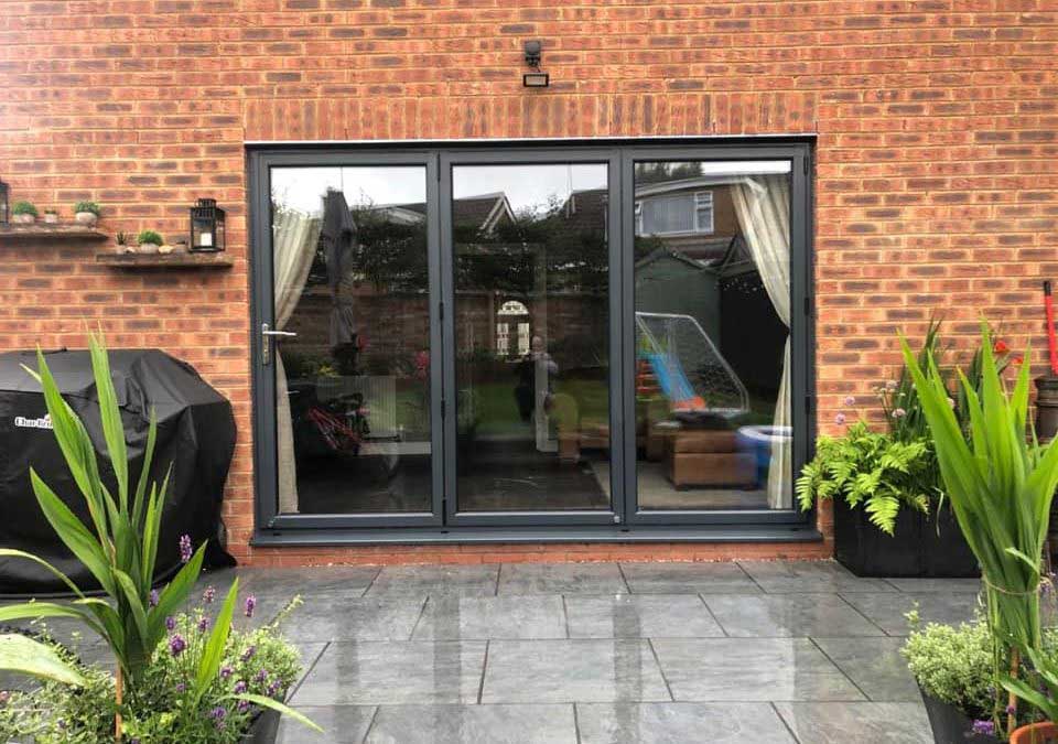Contemporary glass conservatory with pitched roof and floor‑to‑ceiling glazing installed by KP Glass & Windows in Kettering